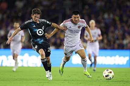 Mar 9, 2024; Orlando, Florida, USA; Orlando City midfielder Cesar Araujo (5) battles for the ball with Minnesota United midfielder Wil Trapp (20) during the first half at Inter & Co Stadium. Mandatory Credit: Nathan Ray Seebeck-USA TODAY Sports