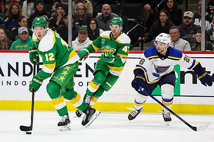 Mar 23, 2024; Saint Paul, Minnesota, USA; Minnesota Wild left wing Matt Boldy (12) skates with the puck as St. Louis Blues left wing Nathan Walker (26) defends during the third period at Xcel Energy Center. Mandatory Credit: Matt Krohn-USA TODAY Sports