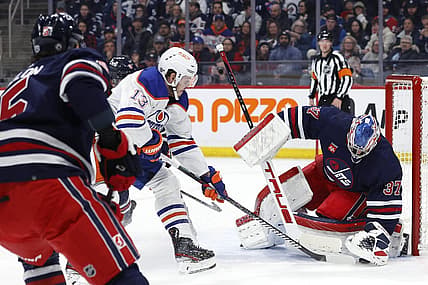 Mar 26, 2024; Winnipeg, Manitoba, CAN; Winnipeg Jets goaltender Connor Hellebuyck (37) covers up a rebound from Edmonton Oilers center Mattias Janmark (13) in the first period at Canada Life Centre. Mandatory Credit: James Carey Lauder-USA TODAY Sports