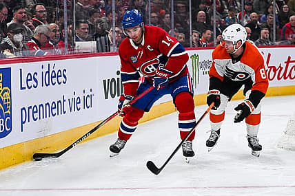 Mar 28, 2024; Montreal, Quebec, CAN; Montreal Canadiens center Nick Suzuki (14) plays the puck against Philadelphia Flyers defenseman Cam York (8) during the second period at Bell Centre. Mandatory Credit: David Kirouac-USA TODAY Sports