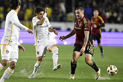Mar 30, 2024; Carson, California, USA; LA Galaxy midfielder Gaston Brugman (5) battles for the ball against Seattle Sounders FC forward Jordan Morris (13) during the first half at Dignity Health Sports Park. Mandatory Credit: Alex Gallardo-USA TODAY Sports