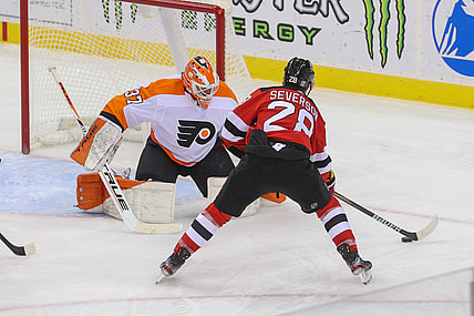 Jan 26, 2021; Newark, New Jersey, USA; New Jersey Devils defenseman Damon Severson (28) skates with the puck while Philadelphia Flyers goaltender Brian Elliott (37) defends his net during the second period at Prudential Center. Mandatory Credit: Ed Mulholland-USA TODAY Sports