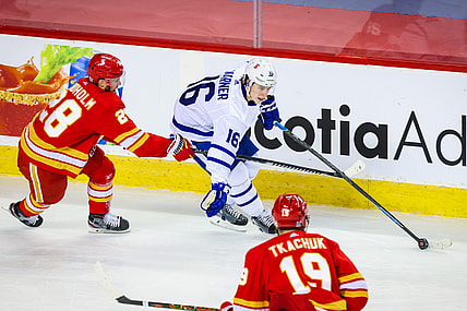 Jan 26, 2021; Calgary, Alberta, CAN; Toronto Maple Leafs center Mitchell Marner (16) controls the puck against Calgary Flames center Elias Lindholm (28) during the second period at Scotiabank Saddledome. Mandatory Credit: Sergei Belski-USA TODAY Sports
