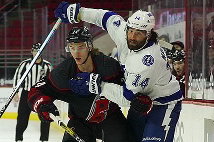 Jan 28, 2021; Raleigh, North Carolina, USA;  Carolina Hurricanes defensemen Jake Bean (24) and Tampa Bay Lightning left wing Pat Maroon (14 watch the play during the first period at PNC Arena. Mandatory Credit: James Guillory-USA TODAY Sports