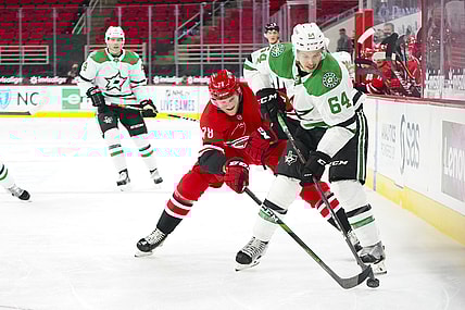 Jan 31, 2021; Raleigh, North Carolina, USA;  Dallas Stars center Tanner Kero (64) tries to control the puck against Carolina Hurricanes center Steven Lorentz (78) at PNC Arena. Mandatory Credit: James Guillory-USA TODAY Sports