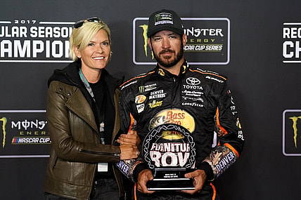 Sep 9, 2017; Richmond, VA, USA; NASCAR Cup Series driver Martin Truex Jr. (78) and his girlfriend Sherry Pollex pose with the NASCAR regular season trophy after the Federated Auto Parts 400 at Richmond International Raceway. Mandatory Credit: Peter Casey-USA TODAY Sports