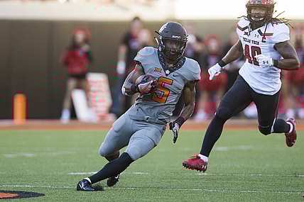 Sep 22, 2018; Stillwater, OK, USA;  Oklahoma State Cowboys cornerback Kemah Siverand (5) runs the ball as Texas Tech Red Raiders linebacker Dakota Allen (40) closes in during the game at Boone Pickens Stadium. Mandatory Credit: Brett Rojo-USA TODAY Sports