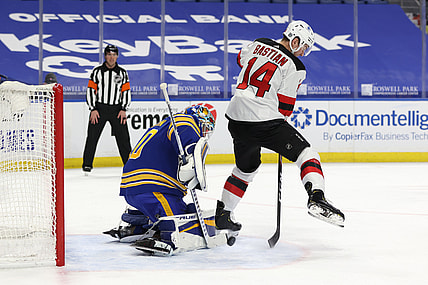 Jan 31, 2021; Buffalo, New York, USA; New Jersey Devils right wing Nathan Bastian (14) deflects a shot on Buffalo Sabres goaltender Carter Hutton (40) during the third period at KeyBank Center. Mandatory Credit: Timothy T. Ludwig-USA TODAY Sports