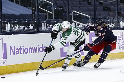 Feb 4, 2021; Columbus, Ohio, USA; Dallas Stars defenseman Esa Lindell (23) passes the puck against Columbus Blue Jackets right wing Patrik Laine (29) in the first period at Nationwide Arena. Mandatory Credit: Aaron Doster-USA TODAY Sports