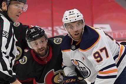 Feb 9, 2021; Ottawa, Ontario, CAN; Ottawa Senators center Derek Stepan (21) and Edmonton Oilers center Connor McDavid (97) follow the puck after a face off in the first period at the Canadian Tire Centre. Mandatory Credit: Marc DesRosiers-USA TODAY Sports