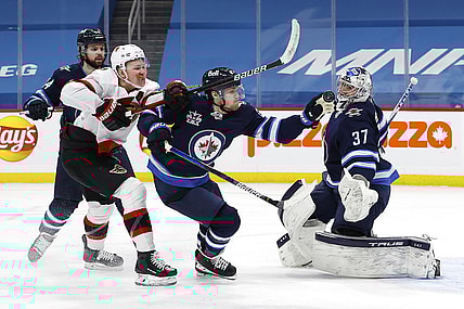 Feb 11, 2021; Winnipeg, Manitoba, CAN; Winnipeg Jets left wing Nikolaj Ehlers (27) gloves down the puck after Ottawa Senators left wing Brady Tkachuk (7) took a shot on goaltender Connor Hellebuyck (37) in the first period at Bell MTS Place. Mandatory Credit: James Carey Lauder-USA TODAY Sports