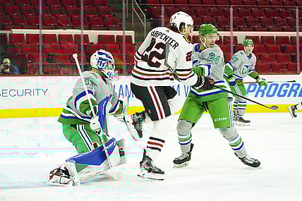 Feb 19, 2021; Raleigh, North Carolina, USA;  Carolina Hurricanes goaltender James Reimer (47) defenseman Jake Bean (24) and Chicago Blackhawks center Ryan Carpenter (22) watch the shot in the first period at PNC Arena. Mandatory Credit: James Guillory-USA TODAY Sports