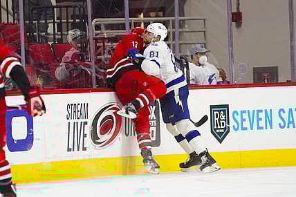 Feb 20, 2021; Raleigh, North Carolina, USA;  Carolina Hurricanes left wing Warren Foegele (13) is checked by Tampa Bay Lightning defenseman Erik Cernak (81) at PNC Arena. Mandatory Credit: James Guillory-USA TODAY Sports