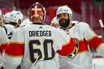 Feb 17, 2021; Raleigh, North Carolina, USA;  Florida Panthers defenseman Radko Gudas (7) celebrates a goal with goaltender Chris Driedger (60) against the Carolina Hurricanes at PNC Arena. Mandatory Credit: James Guillory-USA TODAY Sports