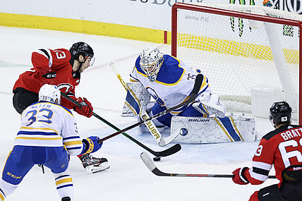 Feb 23, 2021; Newark, New Jersey, USA; New Jersey Devils center Nico Hischier (13) skates with the puck toward Buffalo Sabres goaltender Linus Ullmark (35) during the second period at Prudential Center. Mandatory Credit: Vincent Carchietta-USA TODAY Sports
