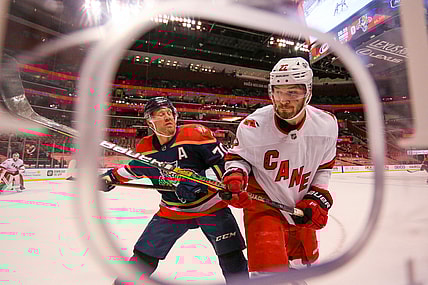 Feb 27, 2021; Sunrise, Florida, USA; Carolina Hurricanes defenseman Brett Pesce (22) gets push against the glass by Florida Panthers right wing Patric Hornqvist (70) during the second period at BB&T Center. Mandatory Credit: Sam Navarro-USA TODAY Sports