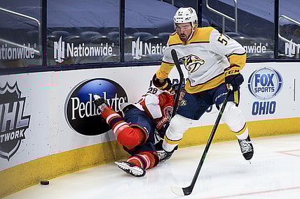 Feb 20, 2021; Columbus, Ohio, USA; Columbus Blue Jackets right wing Oliver Bjorkstrand (28) is checked by Nashville Predators defenseman Dante Fabbro (57) along the boards in the first period at Nationwide Arena. Mandatory Credit: Aaron Doster-USA TODAY Sports