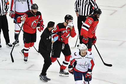 Feb 27, 2021; Newark, New Jersey, USA; New Jersey Devils center Nico Hischier (13) skates off the ice after being hit in the face during a game against the Washington Capitals during the third period at Prudential Center. Mandatory Credit: Catalina Fragoso-USA TODAY Sports