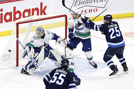 Mar 1, 2021; Winnipeg, Manitoba, CAN;  Vancouver Canucks defenseman Alexander Edler (23) defends against Winnipeg Jets center Paul Stastny (25) as goaltender Thatcher Demko (35) defends the goal in the third period at Bell MTS Place. Mandatory Credit: James Carey Lauder-USA TODAY Sports