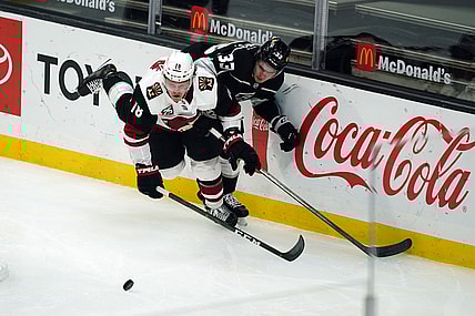 Mar 3, 2021; Los Angeles, California, USA; Arizona Coyotes center Christian Dvorak (18) and LA Kings defenseman Tobias Bjornfot (33) battle for the puck in the second period at Staples Center. Mandatory Credit: Kirby Lee-USA TODAY Sports