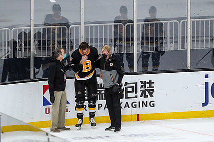Mar 5, 2021; Boston, Massachusetts, USA; Boston Bruins defenseman Brandon Carlo (25) reacts after suffering an apparent injury against the Washington Capitals during the first period at TD Garden. Mandatory Credit: Paul Rutherford-USA TODAY Sports