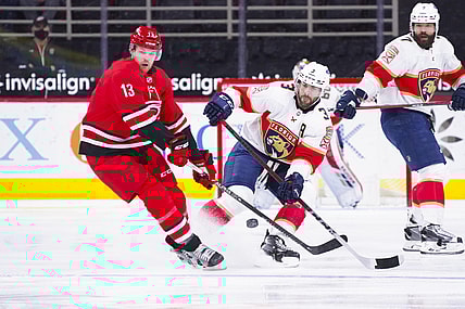 Mar 7, 2021; Raleigh, North Carolina, USA;  Florida Panthers defenseman Keith Yandle (3) chips the puck away from Carolina Hurricanes left wing Warren Foegele (13) during the first period at PNC Arena. Mandatory Credit: James Guillory-USA TODAY Sports