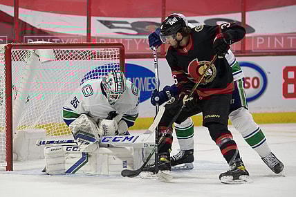 Mar 15, 2021; Ottawa, Ontario, CAN; Vancouver Canucks goalie Thatcher Demko (35) makes a save in front of Ottawa Senators center Colin White (36) in the second period at the Canadian Tire Centre. Mandatory Credit: Marc DesRosiers-USA TODAY Sports