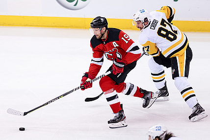 Mar 18, 2021; Newark, New Jersey, USA; New Jersey Devils center Travis Zajac (19) skates with the puck as Pittsburgh Penguins center Sidney Crosby (87) chases during the first period at Prudential Center. Mandatory Credit: Vincent Carchietta-USA TODAY Sports