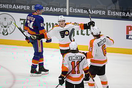 Mar 18, 2021; Uniondale, New York, USA; Philadelphia Flyers left wing Oskar Lindblom (23) celebrates his game winning goal against the New York Islanders with right wing Travis Konecny (11) and defenseman Travis Sanheim (6) in front of Islanders defenseman Scott Mayfield (24) during the third period at Nassau Veterans Memorial Coliseum. Mandatory Credit: Brad Penner-USA TODAY Sports