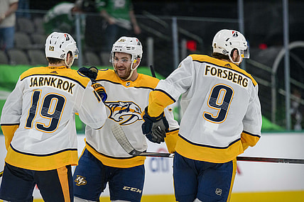 Mar 21, 2021; Dallas, Texas, USA; Nashville Predators center Calle Jarnkrok (19) and defenseman Jeremy Davies (38) and left wing Filip Forsberg (9) celebrate the win over the Dallas Stars at the American Airlines Center. Mandatory Credit: Jerome Miron-USA TODAY Sports