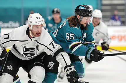 Mar 22, 2021; San Jose, California, USA;  Los Angeles Kings center Jeff Carter (77) and San Jose Sharks defenseman Erik Karlsson (65) chase after the puck during the first period at SAP Center at San Jose. Mandatory Credit: Stan Szeto-USA TODAY Sports