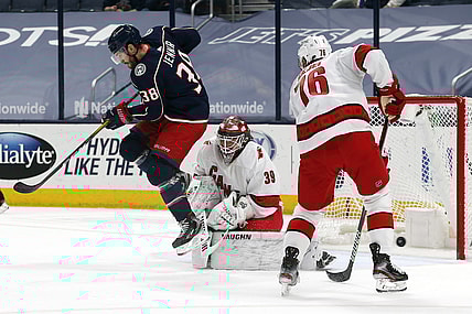Mar 25, 2021; Columbus, Ohio, USA; Carolina Hurricanes goalie Alex Nedeljkovic (39) makes a save through he screen of Columbus Blue Jackets center Boone Jenner (38) during the first period at Nationwide Arena. Mandatory Credit: Russell LaBounty-USA TODAY Sports