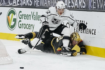 Mar 29, 2021; Las Vegas, Nevada, USA; Los Angeles Kings center Trevor Moore (12) knocks Vegas Golden Knights defenseman Zach Whitecloud (2) to the ice during the first period at T-Mobile Arena. Mandatory Credit: John Locher/POOL PHOTOS-USA TODAY Sports