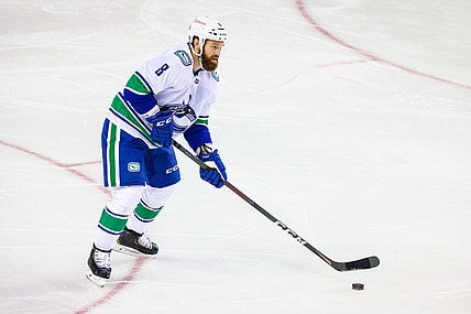 Feb 17, 2021; Calgary, Alberta, CAN; Vancouver Canucks defenseman Jordie Benn (8) controls the puck against the Calgary Flames during the first period at Scotiabank Saddledome. Mandatory Credit: Sergei Belski-USA TODAY Sports