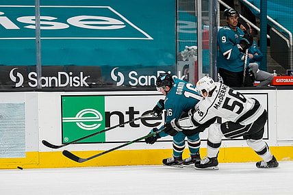 Mar 24, 2021; San Jose, California, USA;  San Jose Sharks center Ryan Donato (16) and Los Angeles Kings defenseman Kurtis MacDermid (56) reaches for the puck during the second period at SAP Center at San Jose. Mandatory Credit: Stan Szeto-USA TODAY Sports