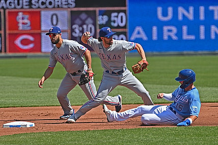 Apr 3, 2021; Kansas City, Missouri, USA; Texas Rangers third basemen Charlie Culberson (2) doubles up Kansas City Royals right fielder Whit Merrifield (15) at second base during the first inning at Kauffman Stadium. Mandatory Credit: Peter Aiken-USA TODAY Sports