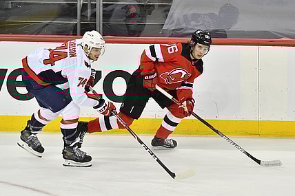Apr 4, 2021; Newark, New Jersey, USA; New Jersey Devils center Jack Houghes (86) skates with the puck against Washington Capitals defenseman John Carlson (74) during the first period at Prudential Center. Mandatory Credit: Catalina Fragoso-USA TODAY Sports