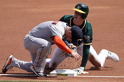 Apr 4, 2021; Oakland, California, USA; Oakland Athletics center fielder Mark Canha (20) slides into third base as Houston Astros third baseman Alex Bregman (2) applies a tag during the first inning at RingCentral Coliseum. Mandatory Credit: Darren Yamashita-USA TODAY Sports