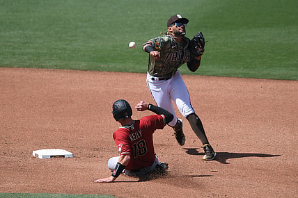 Apr 4, 2021; San Diego, California, USA; San Diego Padres shortstop Fernando Tatis Jr. (R) throws to first base after forcing out Arizona Diamondbacks catcher Carson Kelly (18) at second base during the fourth inning at Petco Park. Mandatory Credit: Orlando Ramirez-USA TODAY Sports