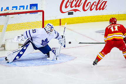 Apr 4, 2021; Calgary, Alberta, CAN; Toronto Maple Leafs goaltender Michael Hutchinson (30) makes a save against Calgary Flames center Mikael Backlund (11) during the first period at Scotiabank Saddledome. Mandatory Credit: Sergei Belski-USA TODAY Sports