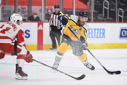 Apr 6, 2021; Detroit, Michigan, USA; Nashville Predators defenseman Mattias Ekholm (14) passes as Detroit Red Wings center Luke Glendening (41) defends during the first period at Little Caesars Arena. Mandatory Credit: Tim Fuller-USA TODAY Sports