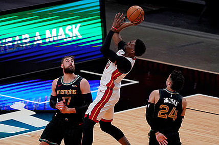Apr 6, 2021; Miami, Florida, USA; Miami Heat center Bam Adebayo (13) shoots the ball between Memphis Grizzlies center Jonas Valanciunas (17) and forward Dillon Brooks (24) during the second half at American Airlines Arena. Mandatory Credit: Jasen Vinlove-USA TODAY Sports