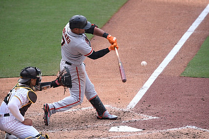 Apr 7, 2021; San Diego, California, USA; San Francisco Giants second baseman Donovan Solano (7) hits a sacrifice fly ball against the San Diego Padres during the tenth inning at Petco Park. Mandatory Credit: Orlando Ramirez-USA TODAY Sports