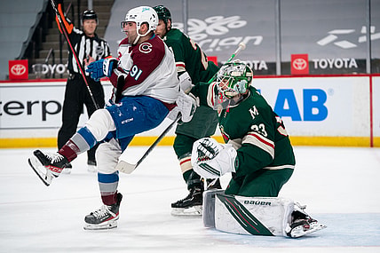 Apr 7, 2021; Saint Paul, Minnesota, USA;  Colorado Avalanche forward Nazem Kadri (91) is cross checked in front of Minnesota Wild goalie Cam Talbot (33) in the first period at Xcel Energy Center. Mandatory Credit: Brad Rempel-USA TODAY Sports