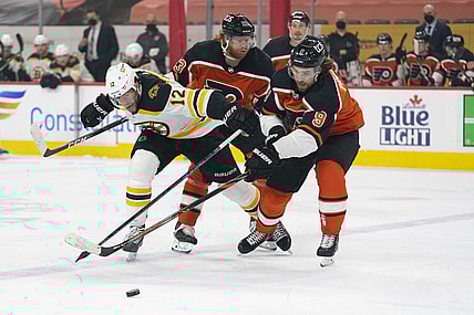 Apr 10, 2021; Philadelphia, Pennsylvania, USA; Boston Bruins right wing Craig Smith (12) battles for the puck against Philadelphia Flyers right wing Jakub Voracek (93) and defenseman Ivan Provorov (9) in the first period at the Wells Fargo Center. Mandatory Credit: Mitchell Leff-USA TODAY Sports