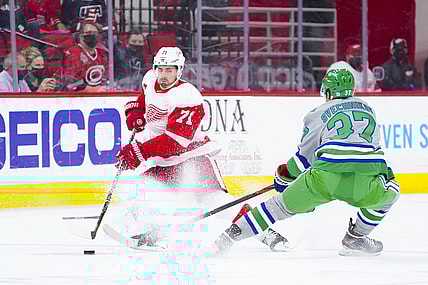 Apr 10, 2021; Raleigh, North Carolina, USA;  Detroit Red Wings center Dylan Larkin (71) tries to control the puck against Carolina Hurricanes right wing Andrei Svechnikov (37) at PNC Arena. Mandatory Credit: James Guillory-USA TODAY Sports