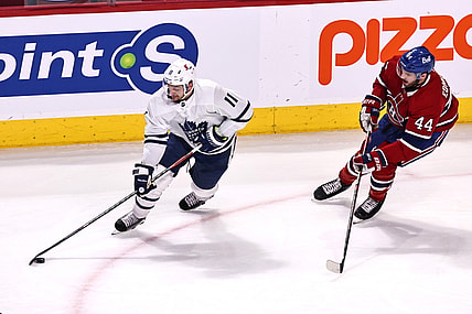 Apr 12, 2021; Montreal, Quebec, CAN; Toronto Maple Leafs left wing Zach Hyman (11) plays the puck against Montreal Canadiens defenseman Joel Edmundson (44) during the first period at Bell Centre. Mandatory Credit: Jean-Yves Ahern-USA TODAY Sports