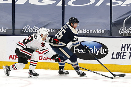 Apr 12, 2021; Columbus, Ohio, USA; Columbus Blue Jackets center Zac Dalpe (26) skates around Chicago Blackhawks center Philipp Kurashev (23) during the first period at Nationwide Arena. Mandatory Credit: Russell LaBounty-USA TODAY Sports