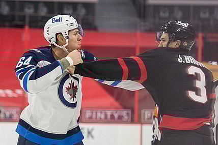 Apr 12, 2021; Ottawa, Ontario, CAN; Winnipeg Jets defenseman Logan Stanley (64) fights with Ottawa Senators defenseman Josh Brown (3) in the first period at the Canadian Tire Centre. Mandatory Credit: Marc DesRosiers-USA TODAY Sports