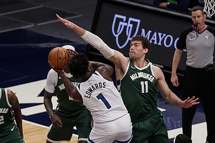 Apr 14, 2021; Minneapolis, Minnesota, USA; Milwaukee Bucks center Brook Lopez (11) defends Minnesota Timberwolves guard Anthony Edwards (1) in the first quarter at Target Center. Mandatory Credit: Brad Rempel-USA TODAY Sports